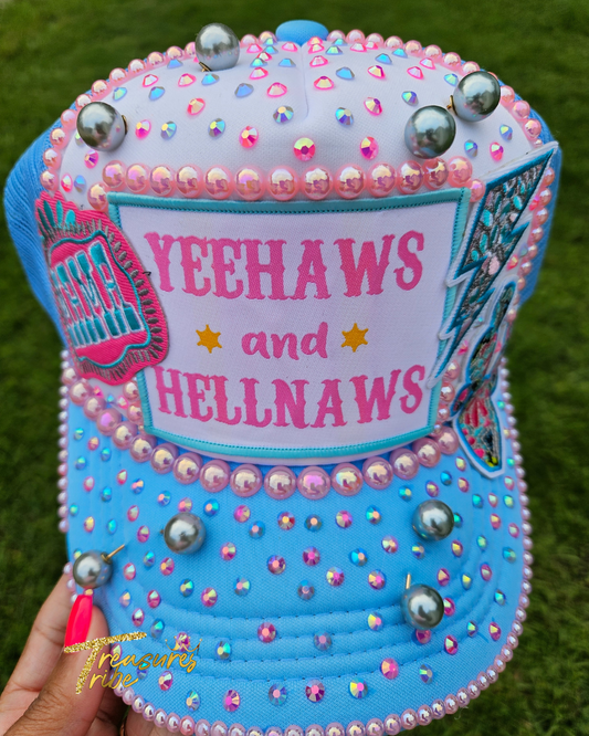 Decorative hat with 'Yeehaws and Hellnaws' text and embellishments on a grass background