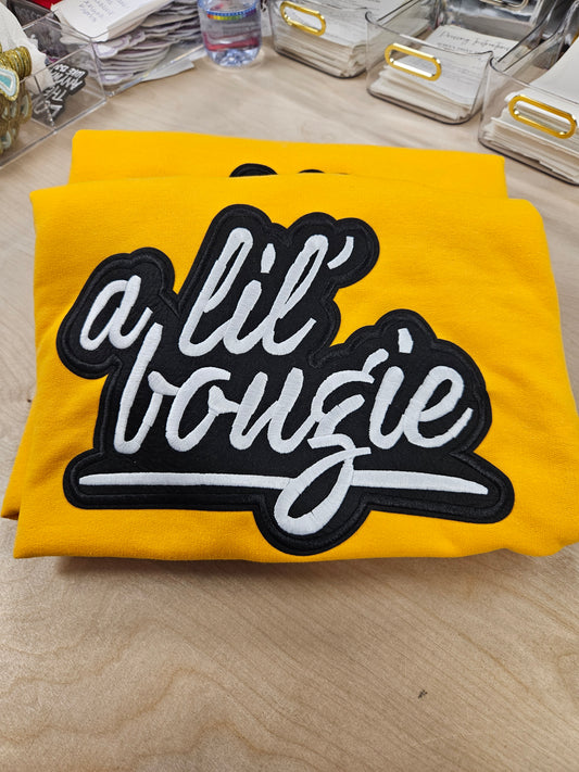 Yellow fabric with a black and white embroidered patch on a wooden surface