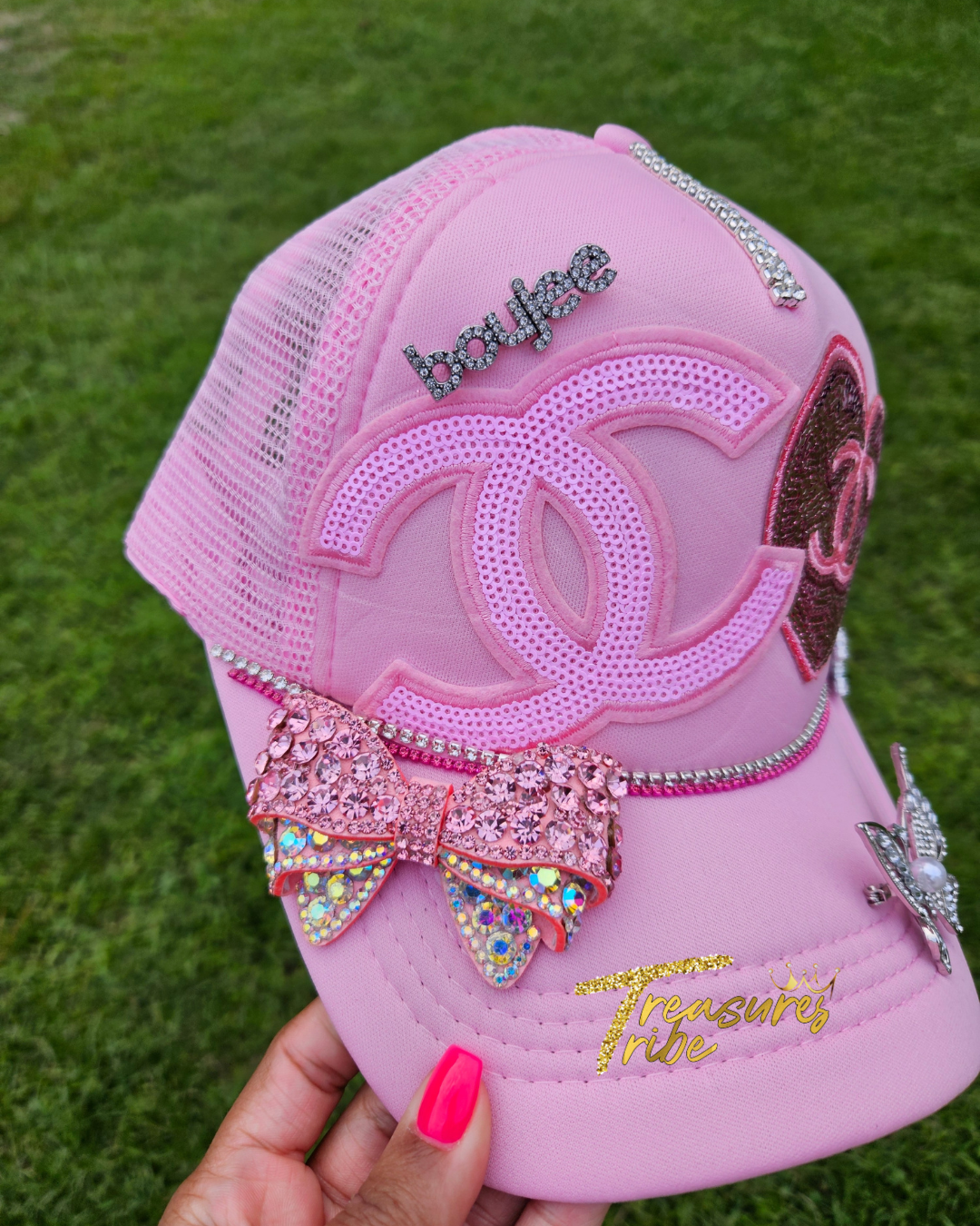 Pink cap with Cha*el elements and embellishments on a grass background
