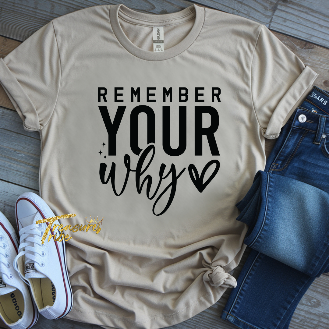 Beige t-shirt with 'Remember Your Why' text, paired with jeans and sneakers on a wooden surface.